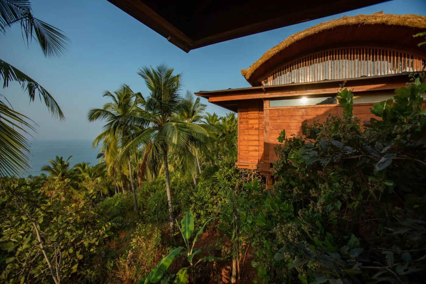 A cottage among palms above the sea at Cabo Serai, Goa.
