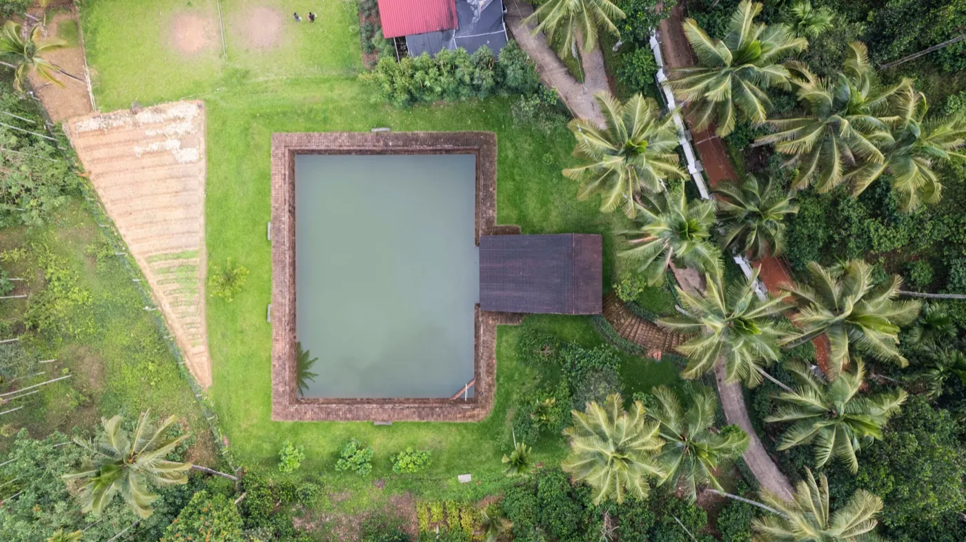 Aerial view of a pool and palms in the grounds of Jeevess Retreat, Wayanad.